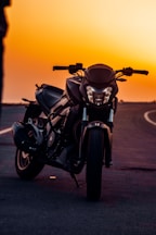 black motorcycle on gray asphalt road during sunset