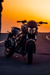 black motorcycle on gray asphalt road during sunset
