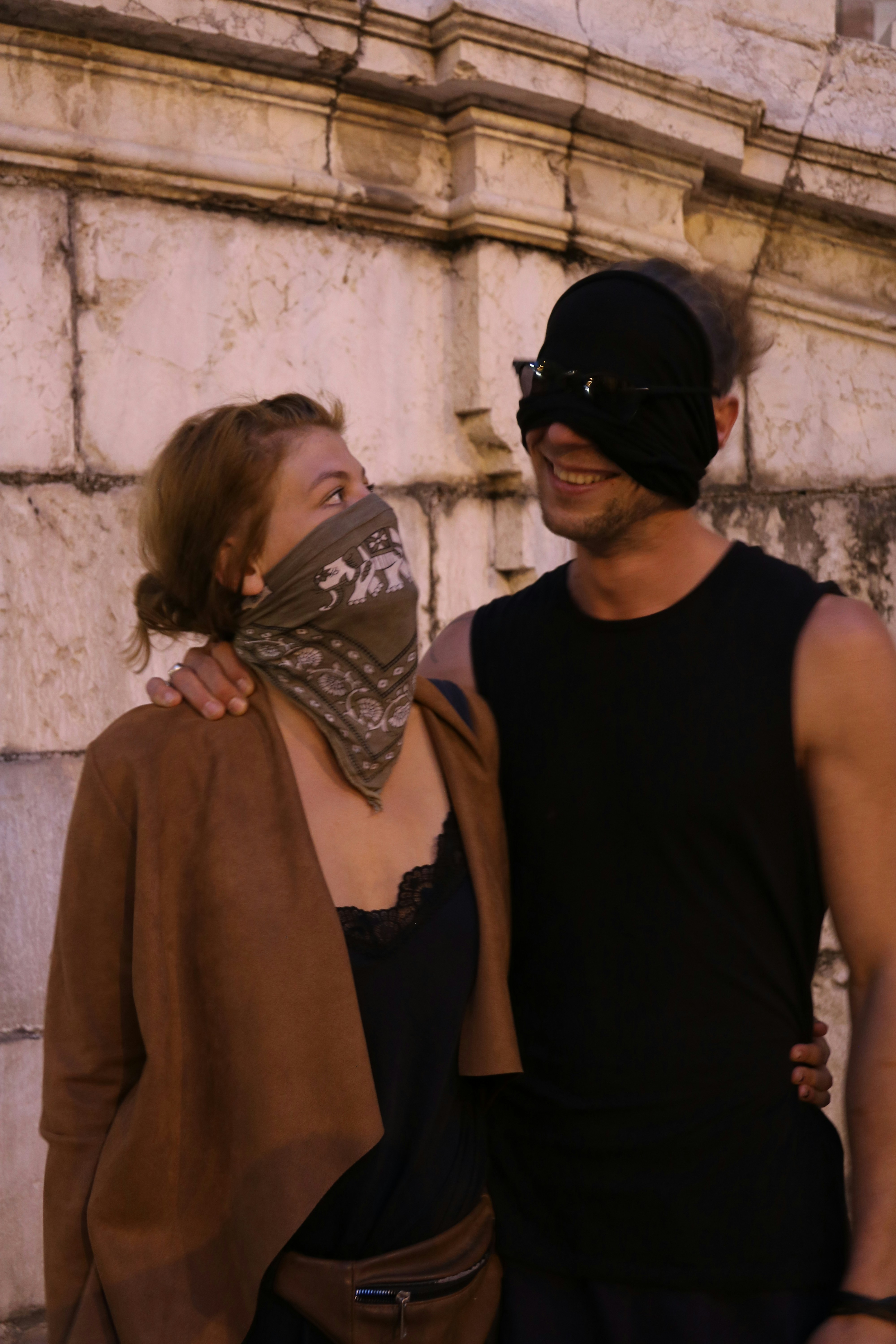 woman in black tank top standing beside woman in brown scarf