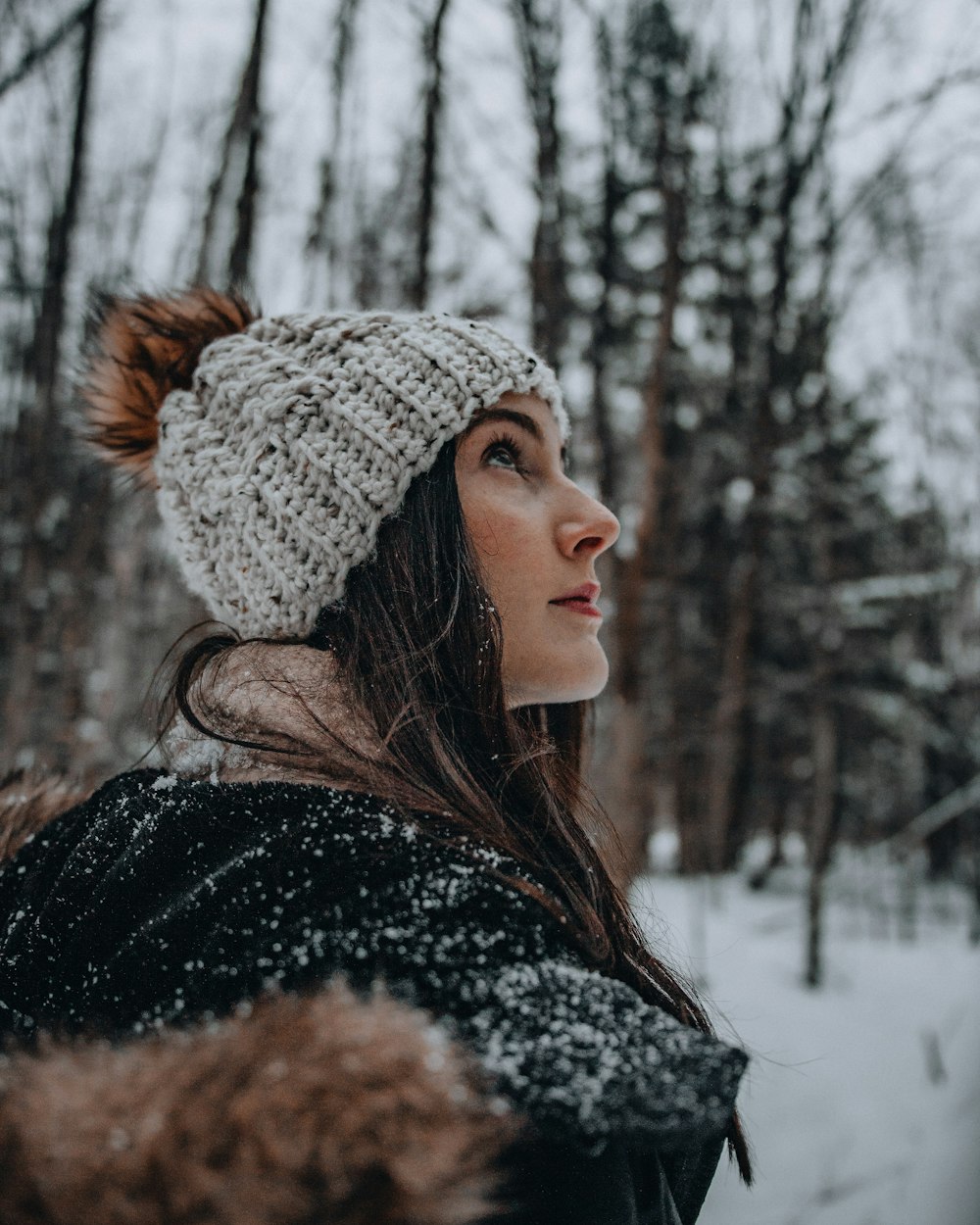 woman in black and white coat wearing gray knit cap