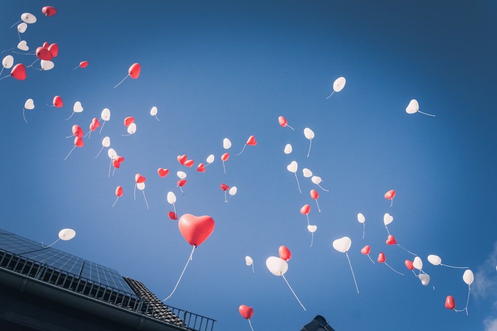 globos rojos del corazón en el cielo durante el día