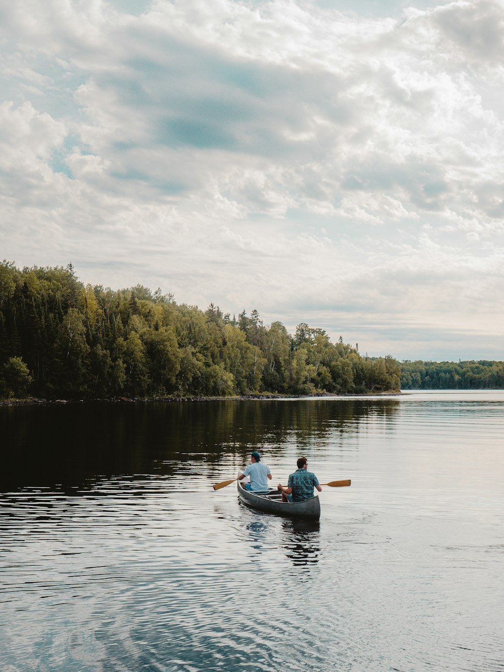 Uomo che cavalca sul kayak blu sul lago durante il giorno