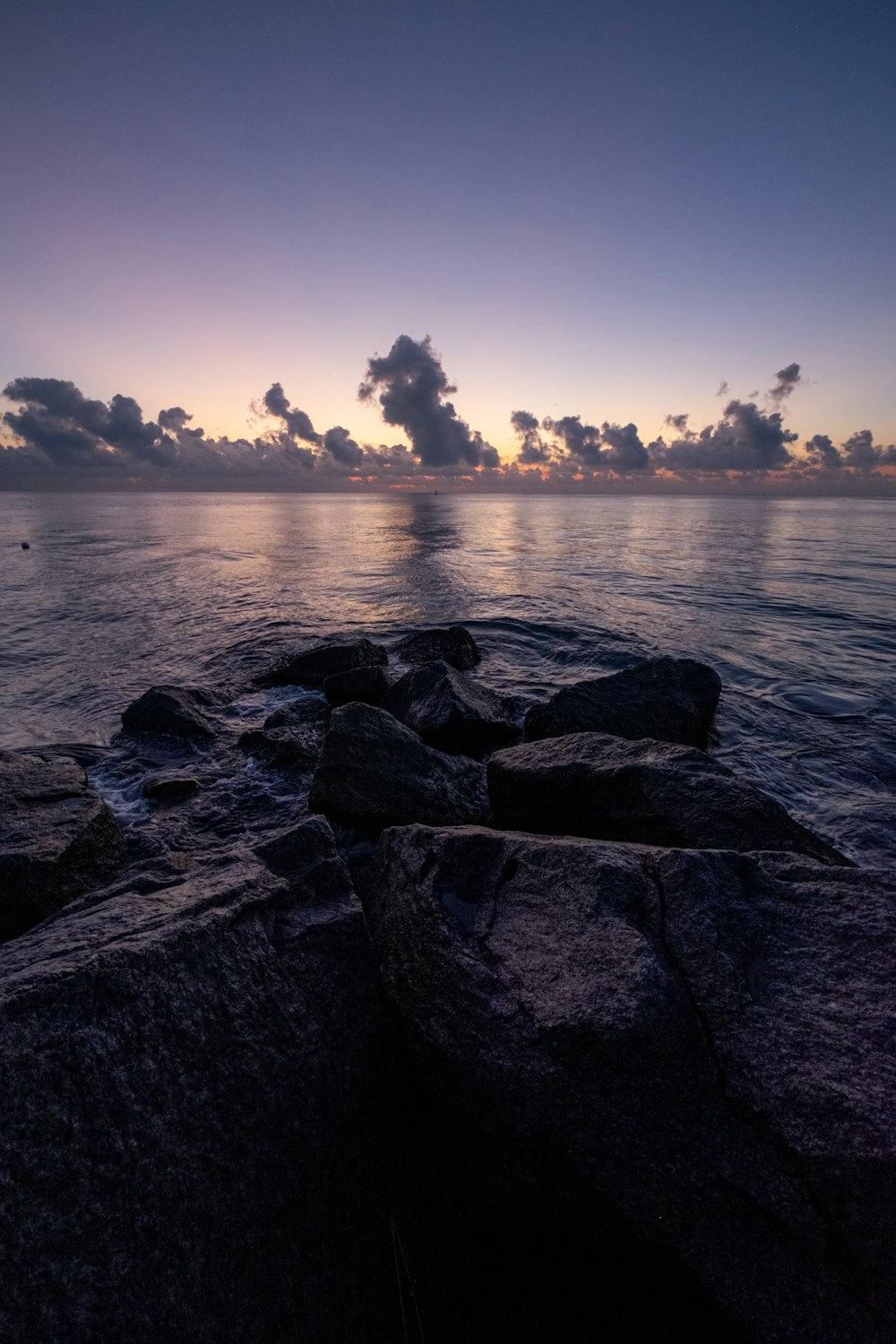 Graue Felsen in der Nähe von Gewässern während des Sonnenuntergangs
