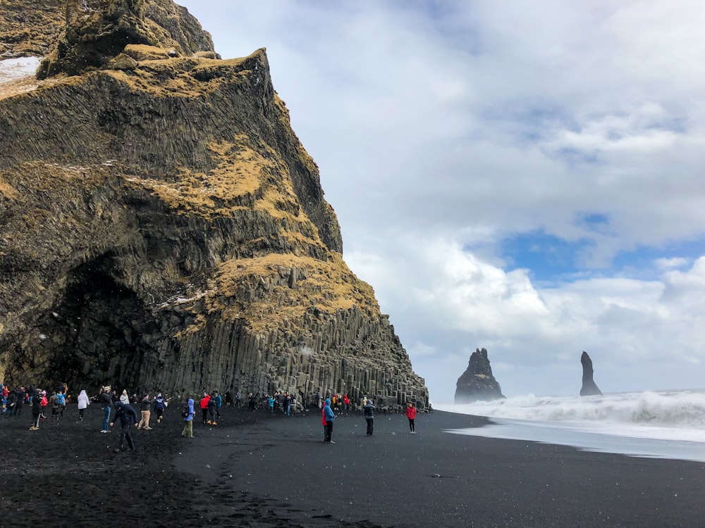 Gente caminando por la playa cerca de las Montañas Rocosas durante el día