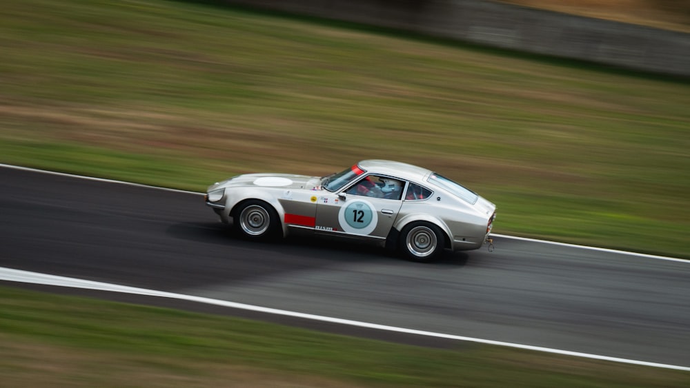 white and red coupe on road during daytime