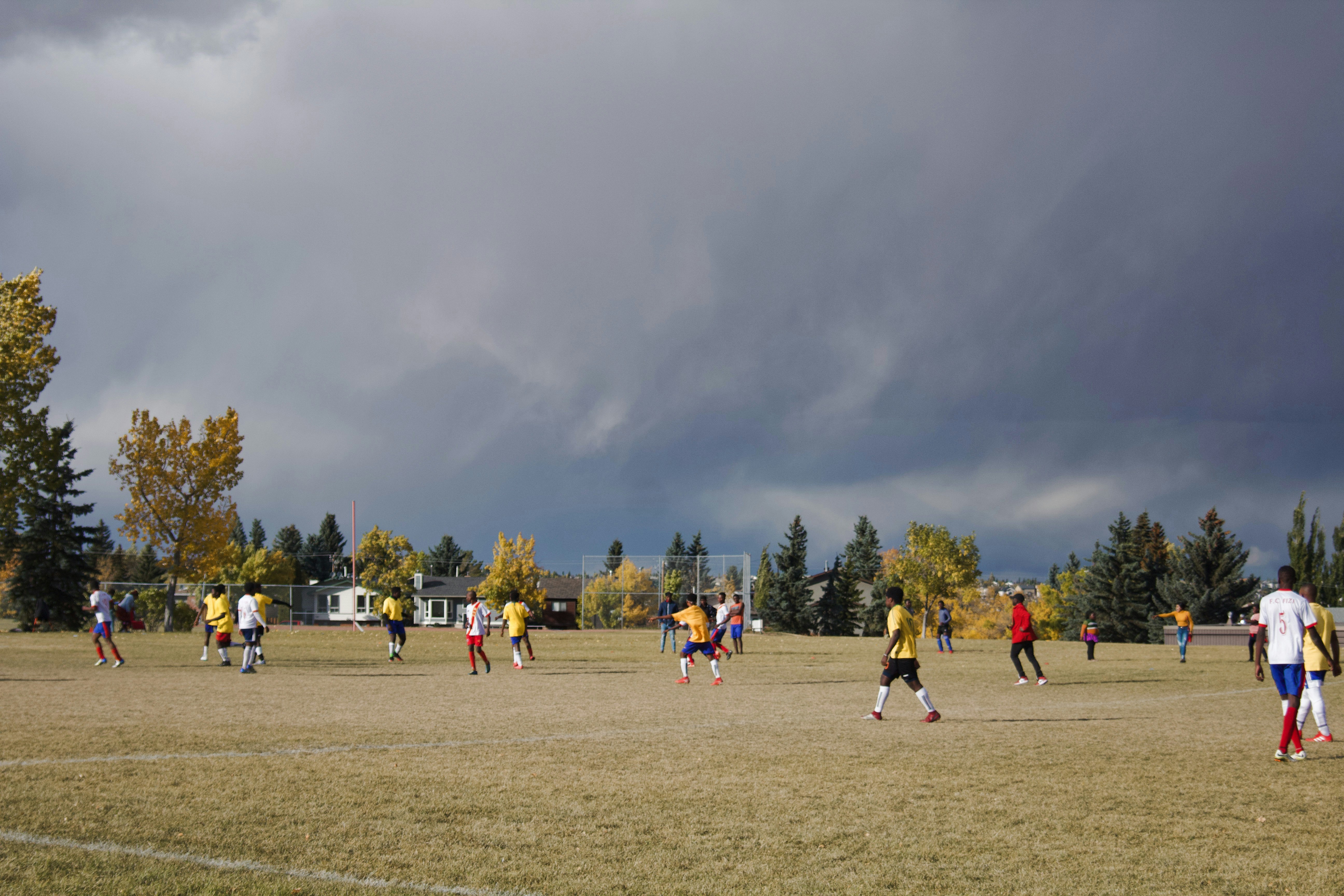people in green and white shirt and pants standing on green grass field during daytime congo teams background