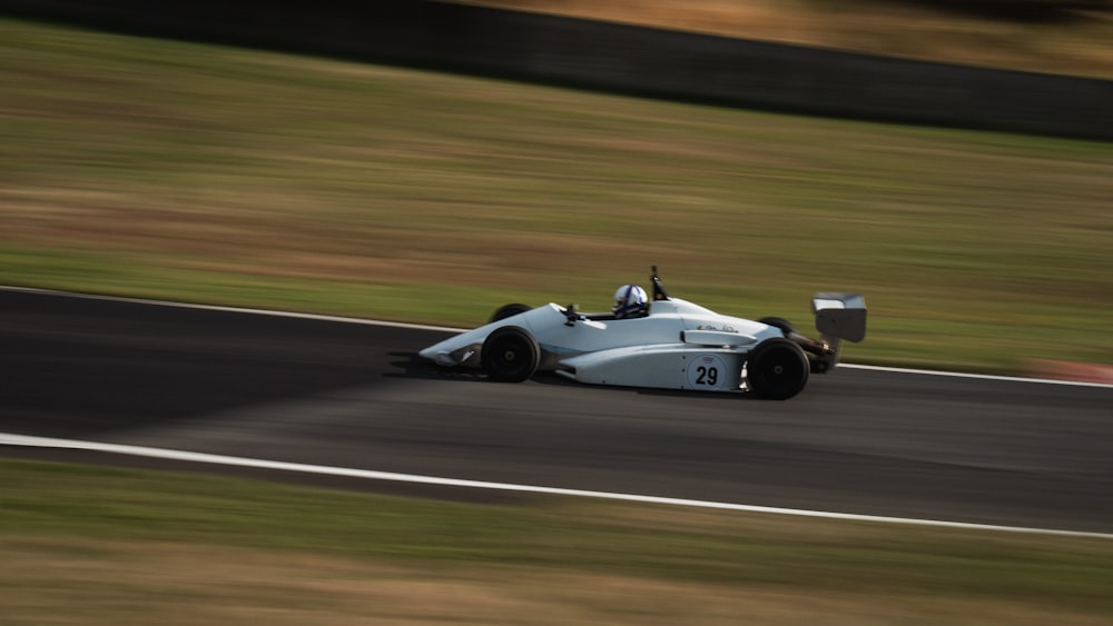 a white race car driving down a race track