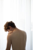 Photo of a physiotherapist gently assisting a patient with shoulder exercises in a bright clinic room.