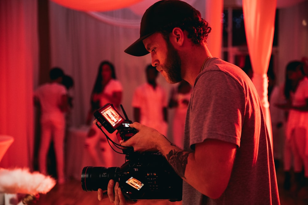 man in gray crew neck t-shirt holding black dslr camera