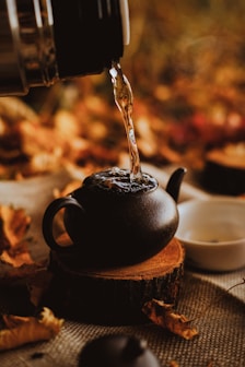 black ceramic teapot pouring water