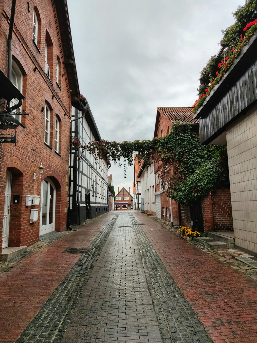 brown brick pathway between brown brick buildings