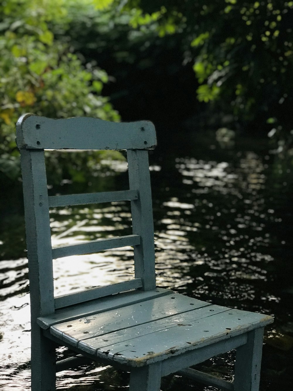 gray wooden chair near body of water during daytime