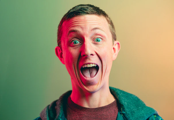 Close-up of a host reacting with surprise and excitement on a vibrant streaming set.