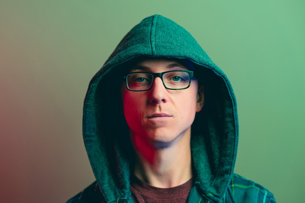 a person wearing a green hoodie and glasses