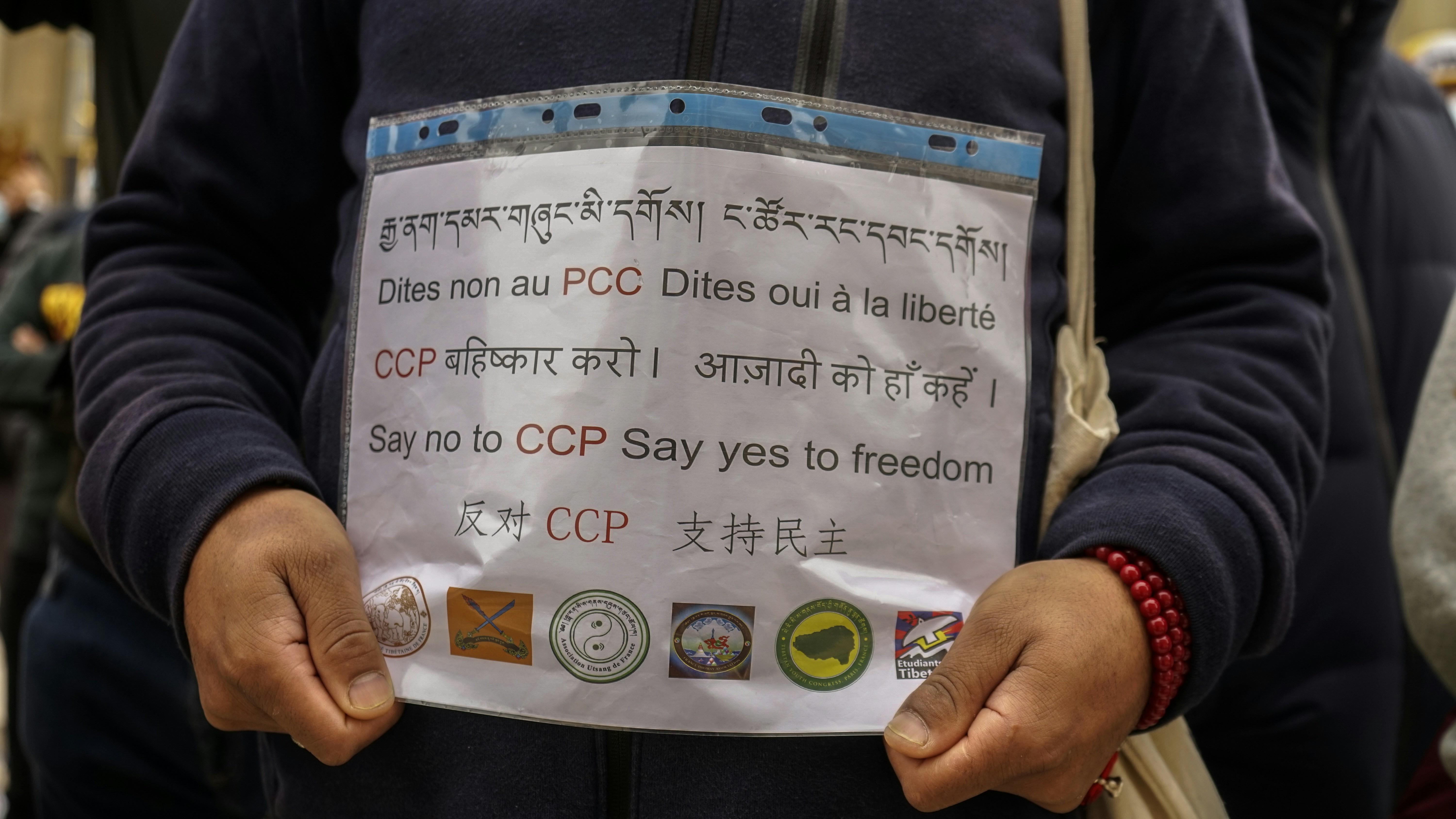 A close-up shot of a party expulsion letter being held, with a blurred background of party symbols and a politician's face.