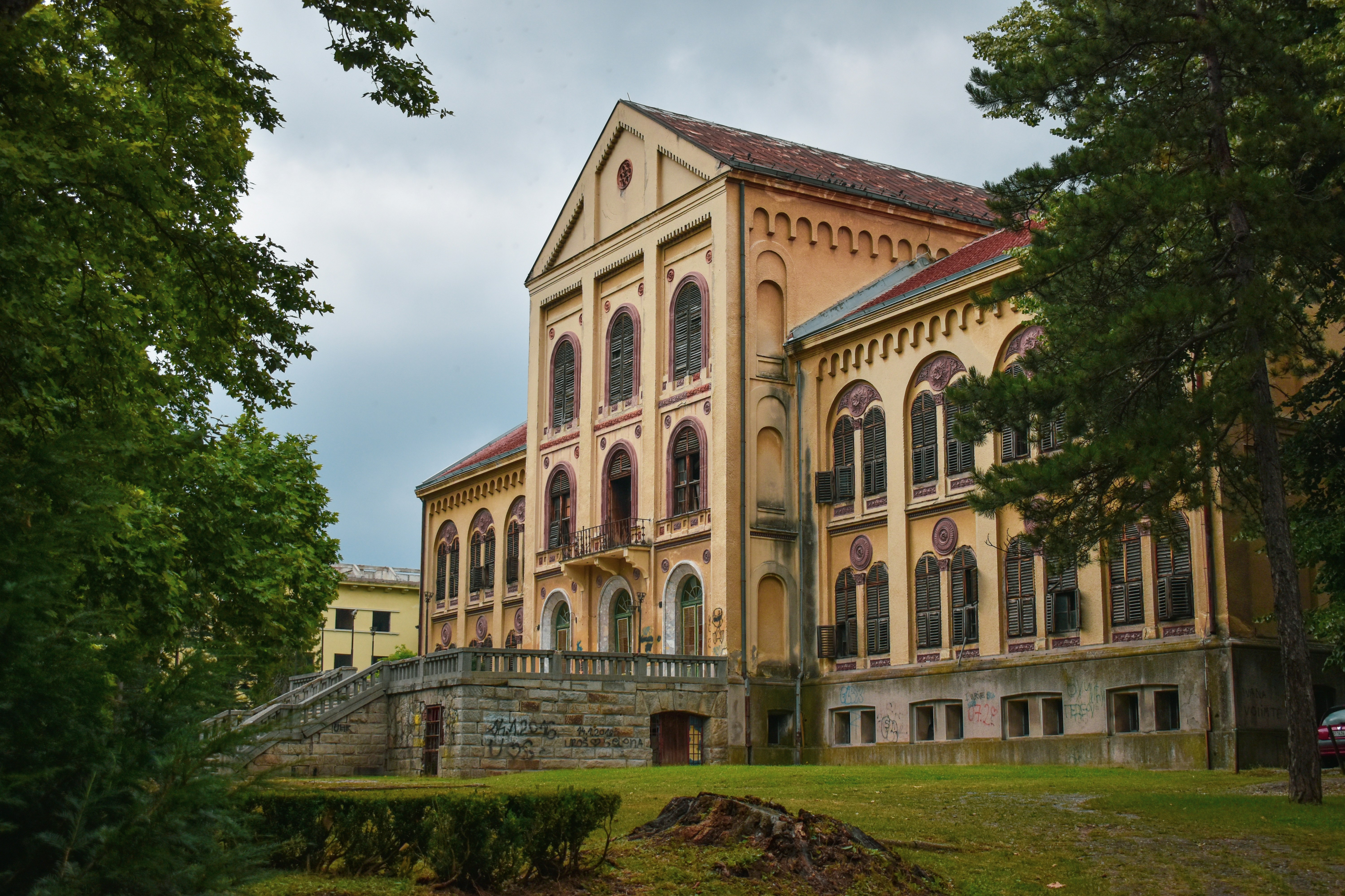 brown concrete building near green trees during daytime