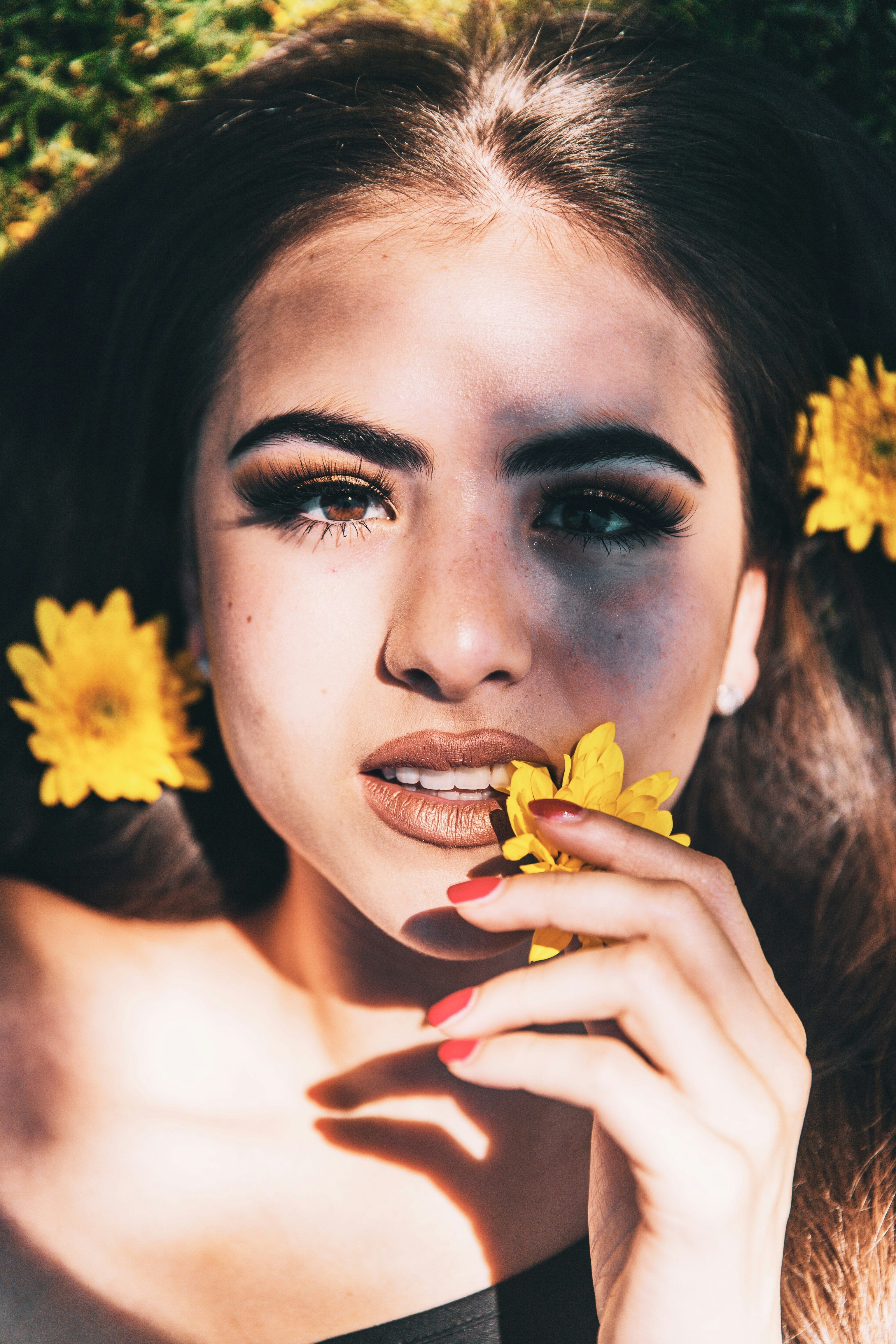 woman with red lipstick holding yellow flower