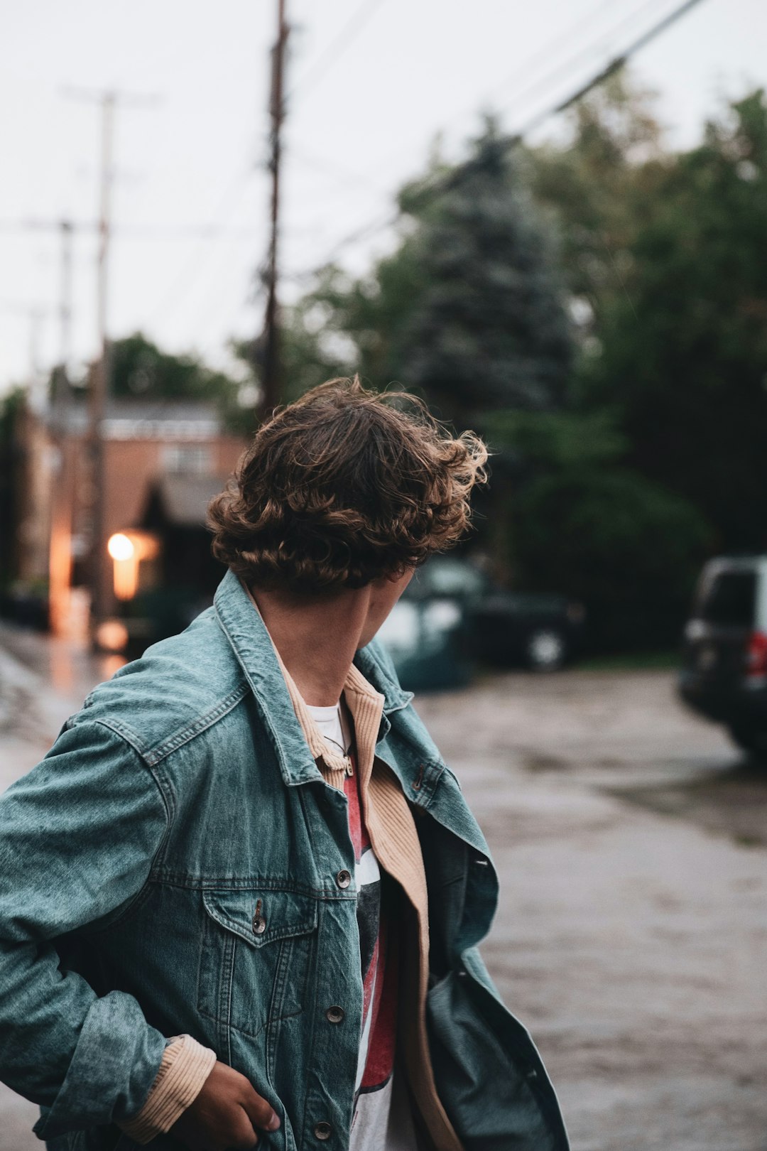 woman in blue denim jacket standing on road during daytime