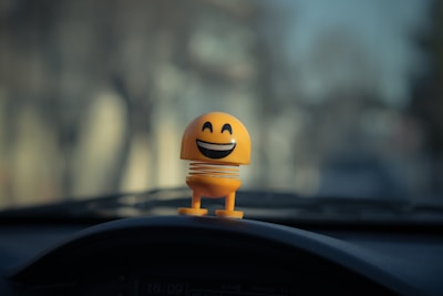 yellow emoji toy on car