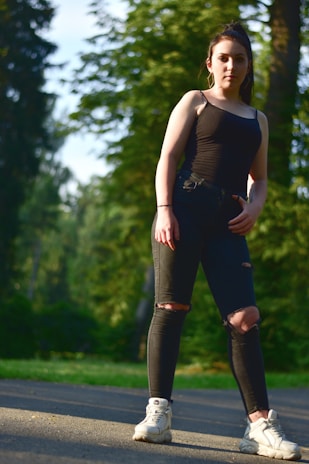 A midlife woman walking confidently along a forest trail, sunlight filtering through trees.