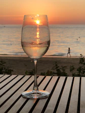 A warm sunset-lit villa terrace where friends share laughter over glasses of wine, capturing genuine connection and luxury ambiance.