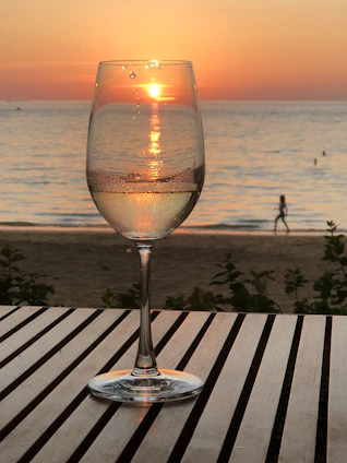 A warm sunset-lit villa terrace where friends share laughter over glasses of wine, capturing genuine connection and luxury ambiance.