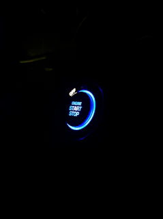 A glowing red emergency button pulsing softly against a dark background, inviting immediate action.