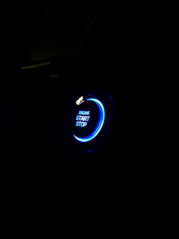 A glowing red emergency button pulsing softly against a dark background, inviting immediate action.