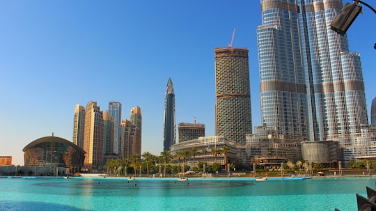 high rise buildings near body of water during daytime in The Dubai Fountain United Arab Emirates
