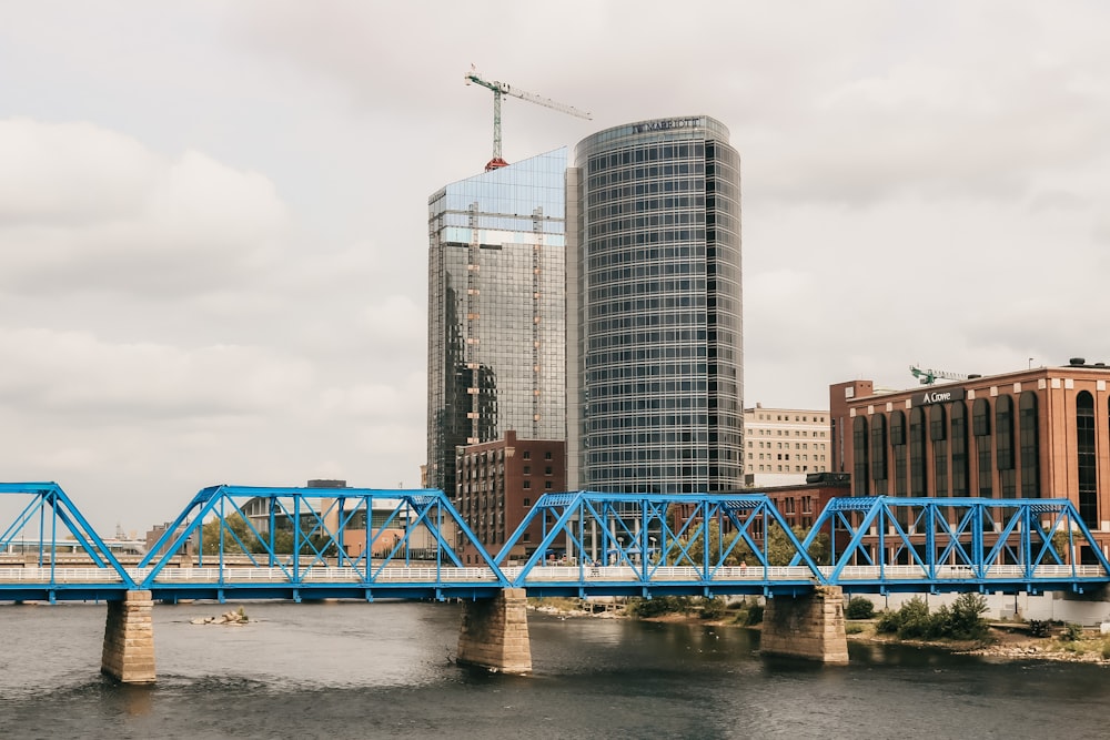 昼間、市の建物近くの川に架かる青い金属橋