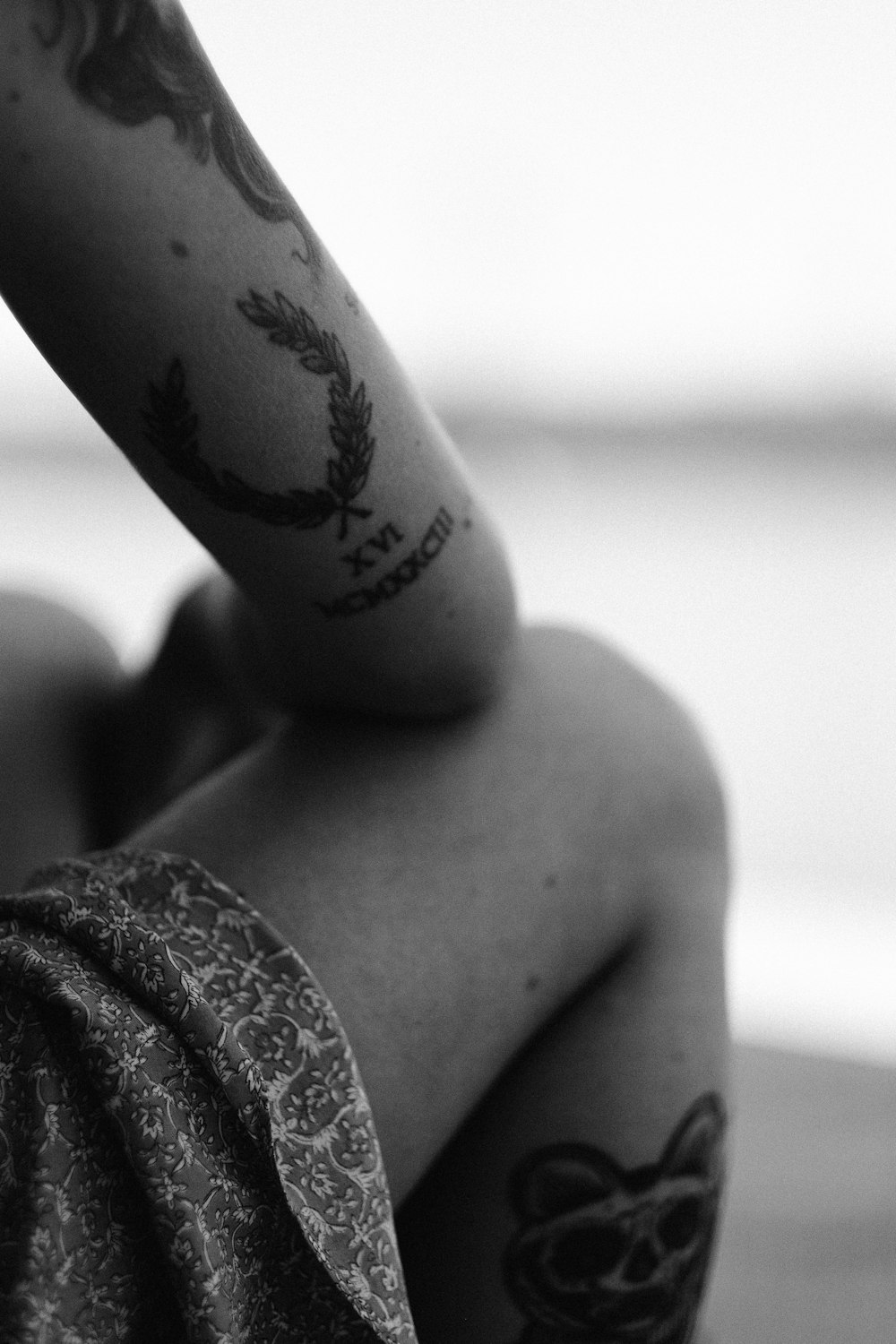 Photo en niveaux de gris d’une femme avec un tatouage sur le dos