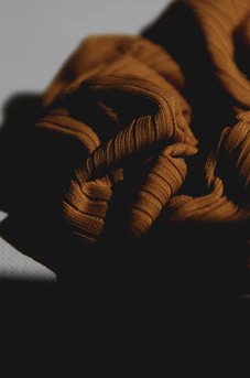 An asymmetrical close-up of textured fabric folds, capturing subtle light and shadow play in monochrome.