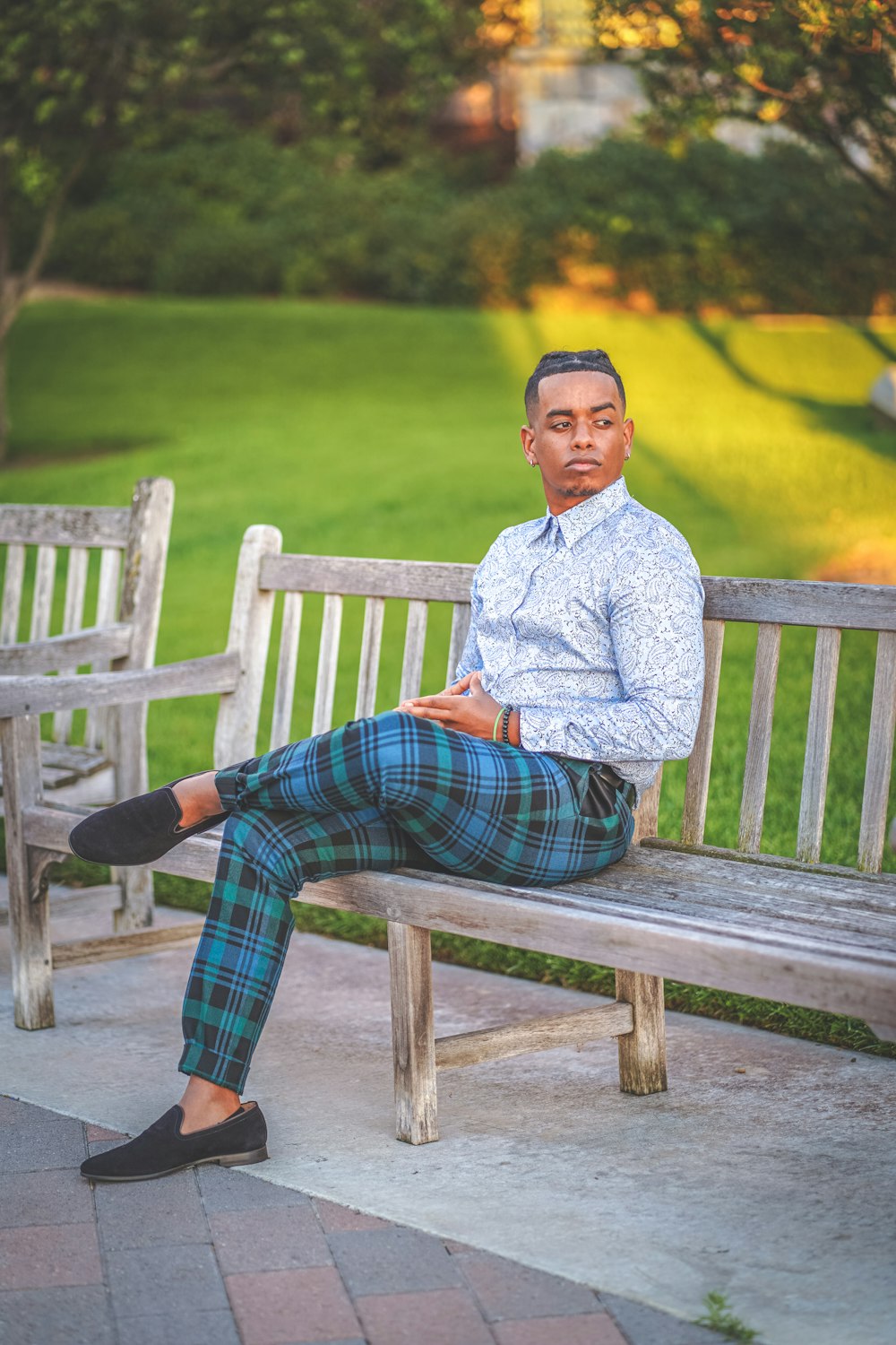 man in gray sweater sitting on brown wooden bench