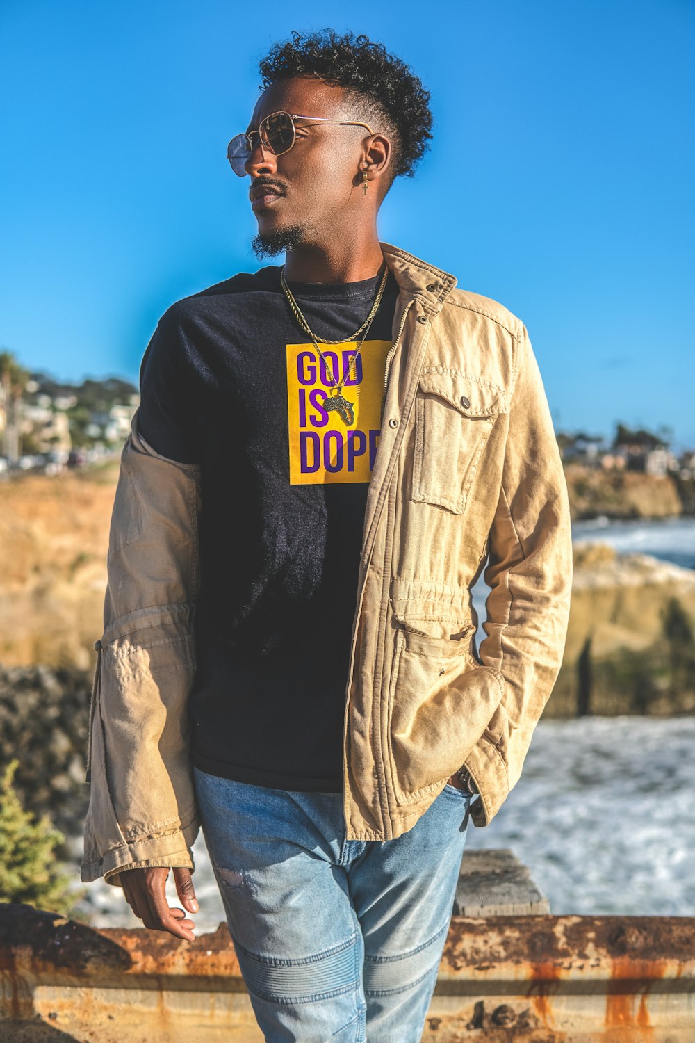 man in brown jacket and blue denim jeans standing on snow covered ground during daytime