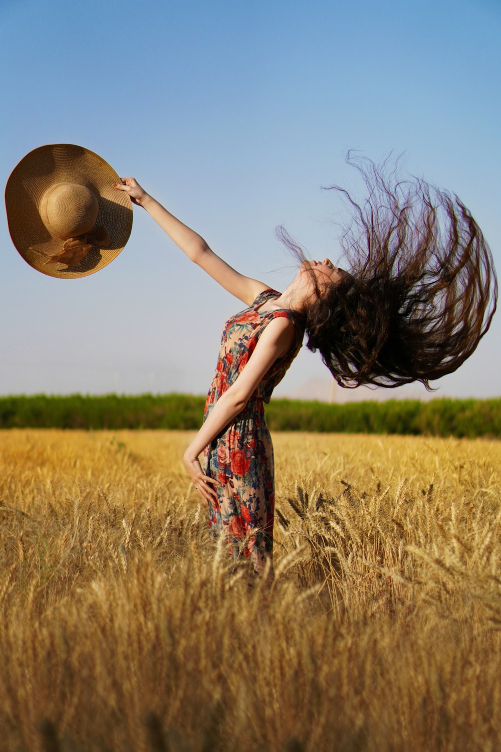 woman in red and green floral dress standing on brown grass field during daytime