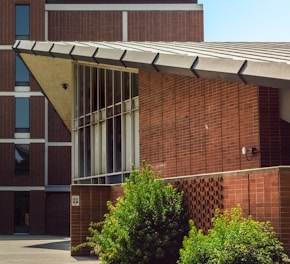 brown brick building near green trees during daytime