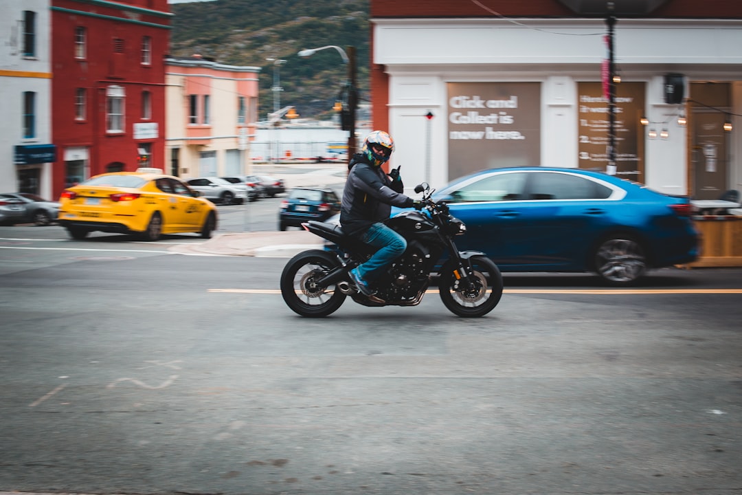 man riding motorcycle on road during daytime