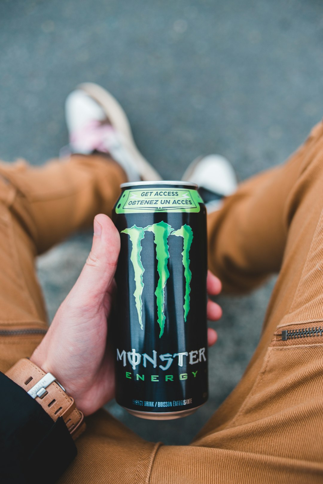 person holding monster energy drink can