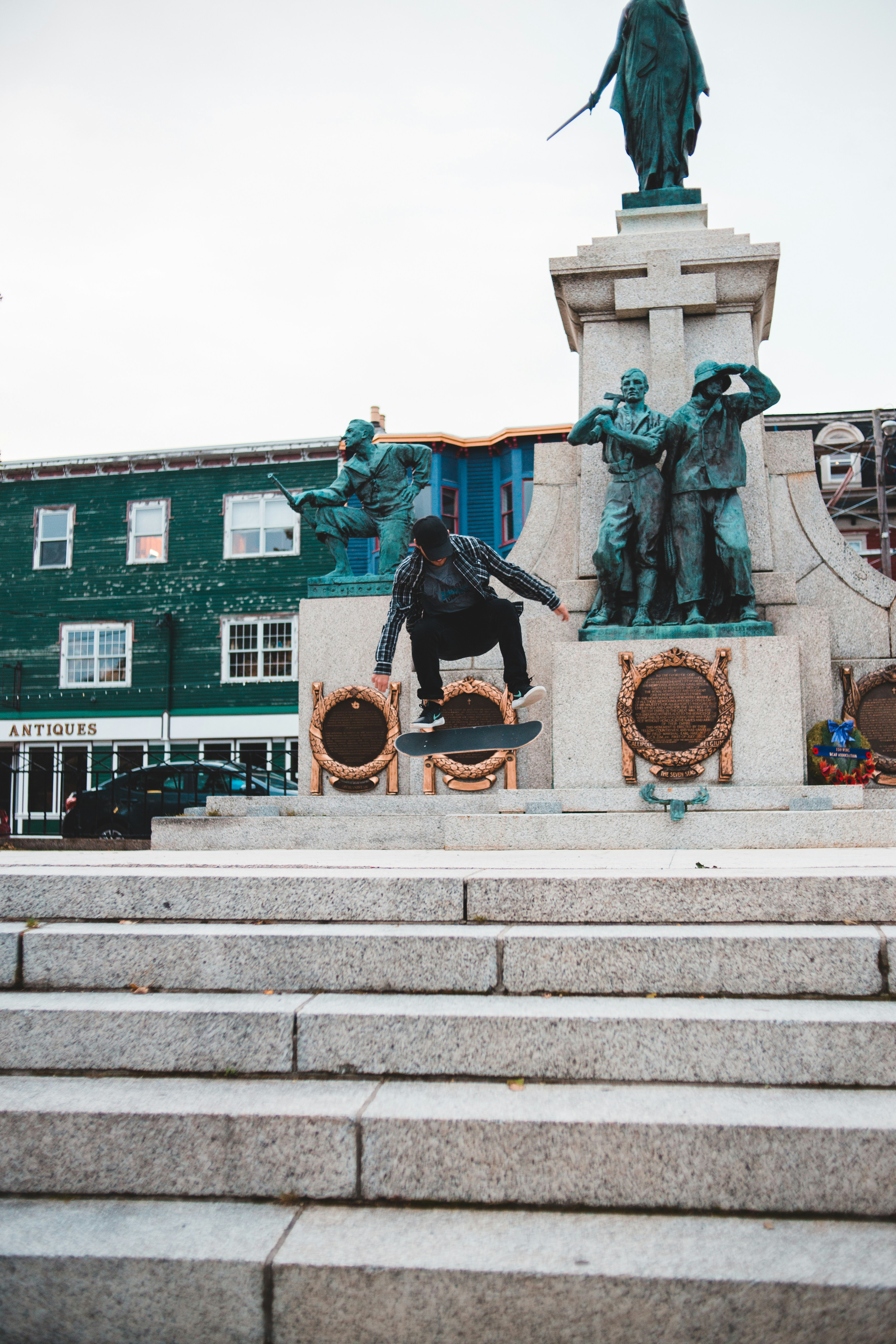 man in black jacket and black pants sitting on concrete bench during daytime