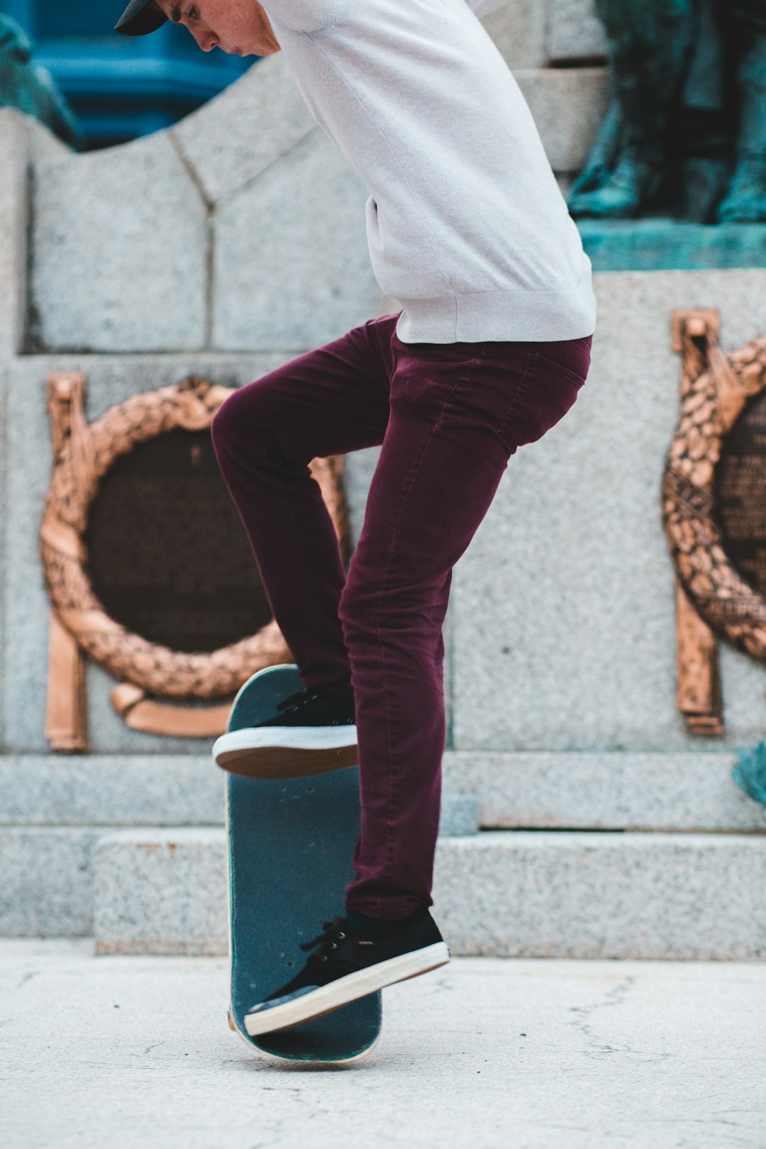 woman in white shirt and blue denim jeans standing on gray concrete floor