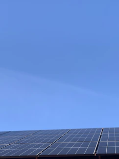 A sleek solar panel angled towards the sun on a clear day.