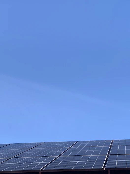 A sleek solar panel glistening under a bright blue sky on a sunny day.
