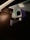 A security camera is mounted on a metal bracket attached to a wall. The camera is positioned under a glass surface with visible screws and brackets. The environment is dimly lit, highlighting the camera's body and the glowing infrared lights around the lens.