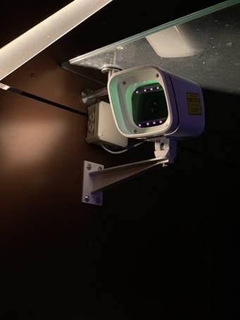 Outdoor security camera mounted on a house exterior at night with visible infrared lights.