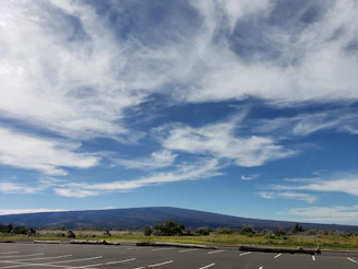 A spacious green lot with clear skies and distant mountains.