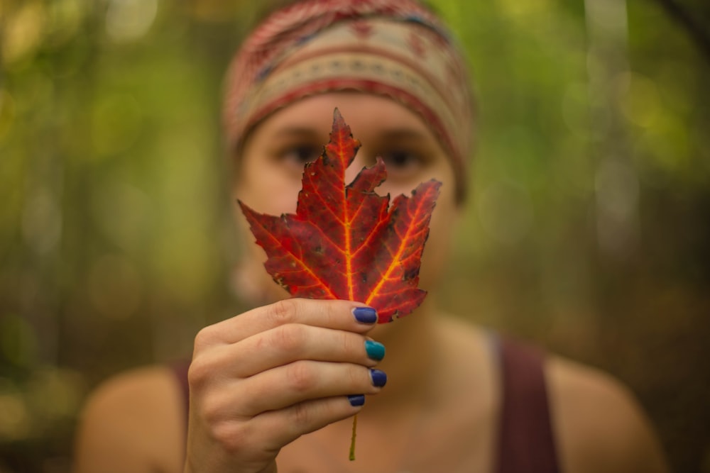 woman holding red maple leaf