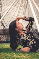 woman in black and white floral long sleeve shirt standing on green grass field during daytime