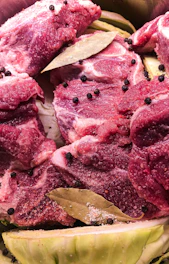 sliced raw meat on brown wooden chopping board