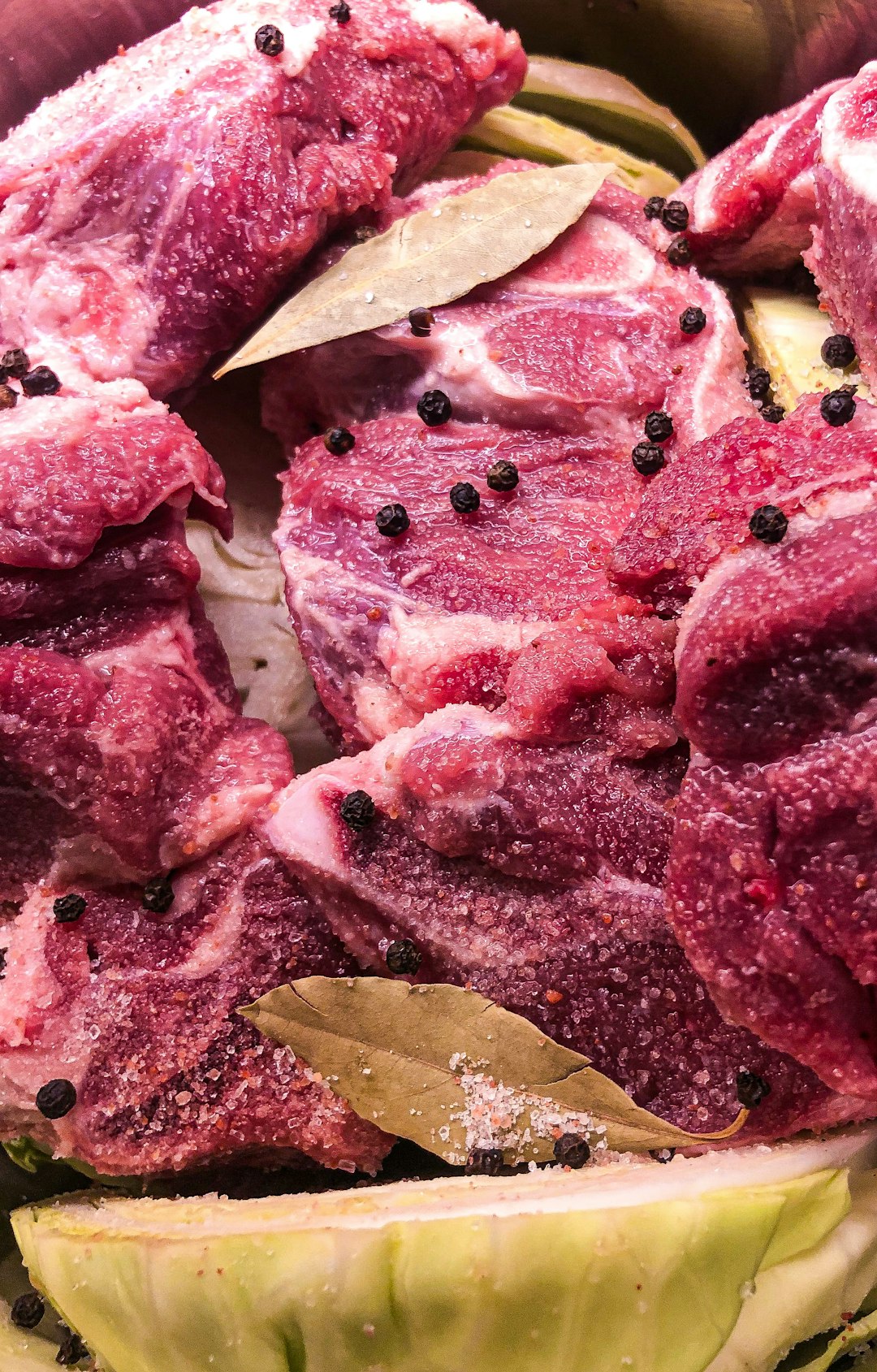 sliced raw meat on brown wooden chopping board