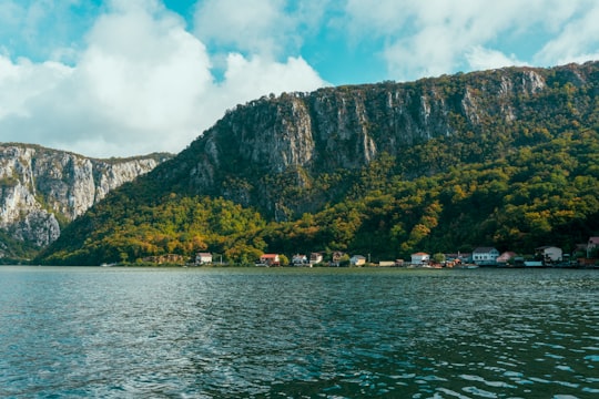 body of water near mountain during daytime in Dubova Romania